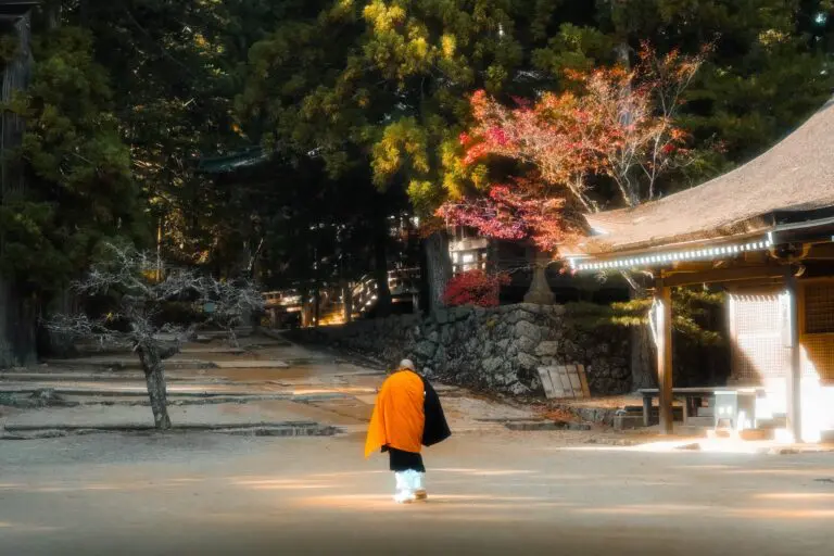 monk walking towards a temple in a Japanese forest